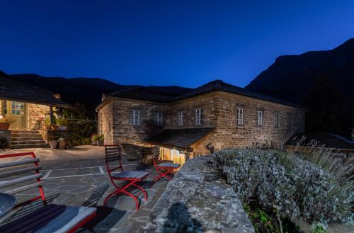 a brick building with a bench in front of it at Papaevangelou Hotel in Papigko