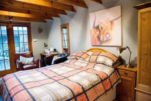 um quarto com uma cama com uma vaca na parede em Kirkstyle Hideaway em Arbroath