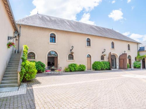 a large white church with a brick driveway at Cottage du Château classé du tourisme 2 étoiles in Bouresse