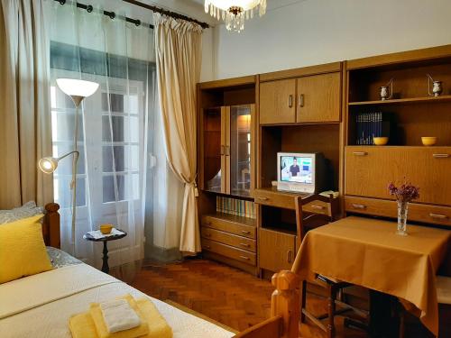 a bedroom with a bed and a table and a television at Mary Apartments in Almada