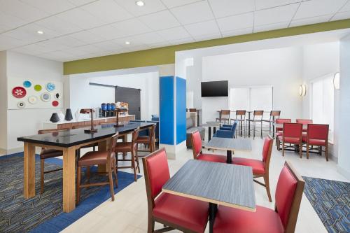 a dining room with tables and chairs at Holiday Inn Express Hotel & Suites Port Richey by IHG in Port Richey