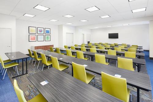 an empty classroom with tables and yellow chairs at Holiday Inn Express Hotel & Suites Port Richey by IHG in Port Richey