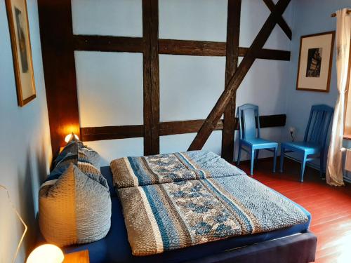 ein Schlafzimmer mit einem Bett und zwei blauen Stühlen in der Unterkunft Adelshof Quedlinburg in Quedlinburg