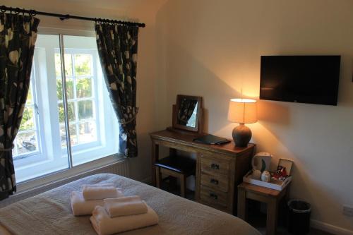 a bedroom with a bed with two pillows and a window at The Chequers Inn in Froggatt