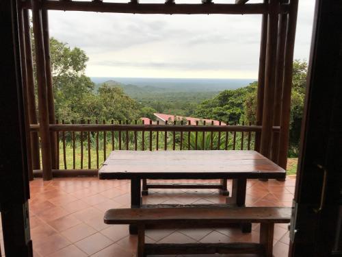 a wooden bench sitting on a balcony with a view at Amafu Forest Lodge in Hoedspruit