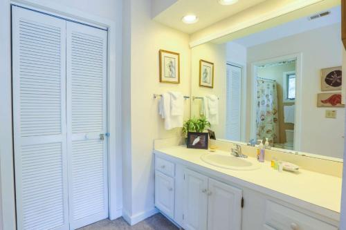 ein Badezimmer mit Waschbecken und Spiegel in der Unterkunft Spriggs Shack in Kiawah Island