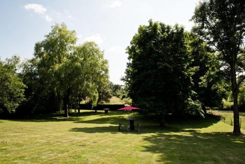 a park with trees and a picnic table in the grass at Gîte La feuille d'Acanthe in Bucilly