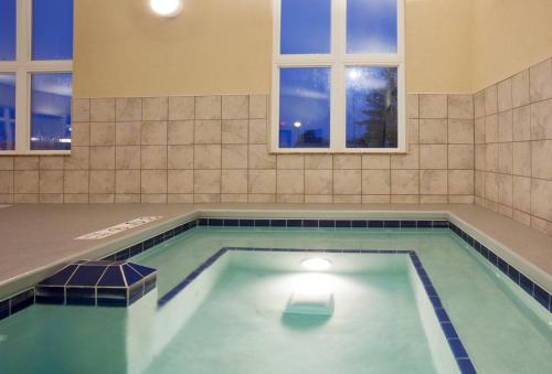 a swimming pool in a room with windows at Holiday Inn Express Hotel & Suites Antigo, an IHG Hotel in Antigo