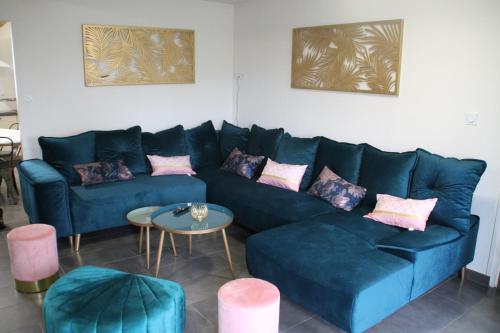 a living room with a blue couch and a table at Gîte La feuille d'Acanthe in Bucilly