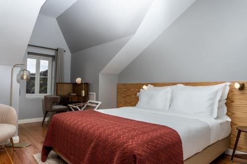 a bedroom with a large bed with a red blanket at 1905 Zino's Palace in Ponta do Sol