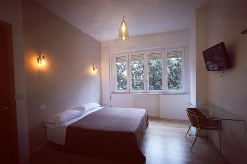 a bedroom with a bed and a tv and a window at Guest House Arte in Rome