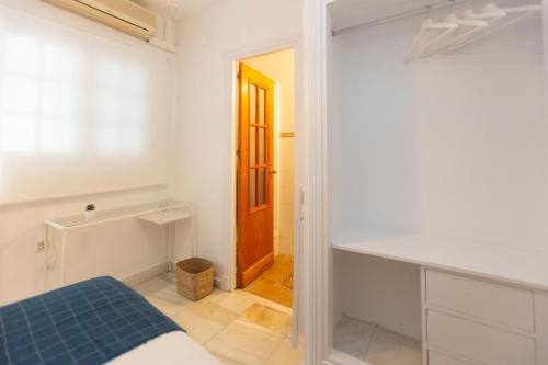 a bedroom with a bed and a wooden door at BOHEMIA SANLUCAR in Sanlúcar de Barrameda