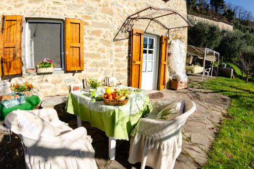 a table and chairs in front of a stone house at La Casa del Sole in Petrognano