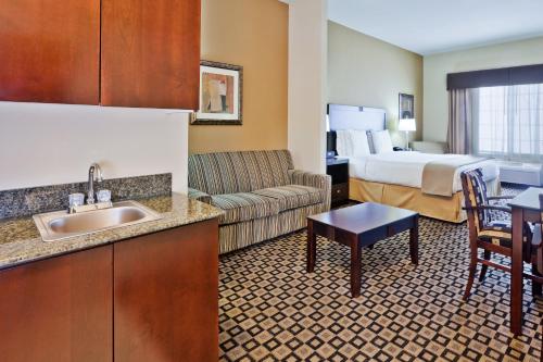 a hotel room with a bed and a living room at Holiday Inn Express & Suites Clovis, an IHG Hotel in Clovis