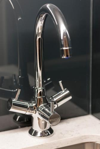 a bathroom sink with a chrome faucet at The Resident Victoria in London