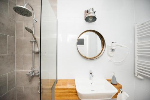 a bathroom with a sink and a mirror and a shower at Villa Lulu Piaseczno in Piaseczno