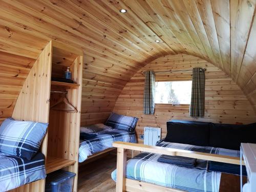 a bedroom with a bed and a window at Craskie Glamping Pods in Inverness