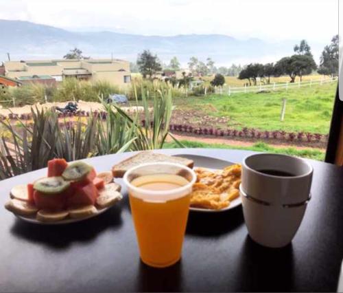 a table with a plate of food and a cup of coffee at Altozano Cabañas in Guatavita