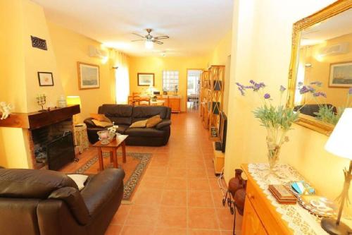 ein Wohnzimmer mit Couch und Kamin in der Unterkunft AME447 Chalet con piscina privada 9x5m y jardín vallado in Les tres Cales