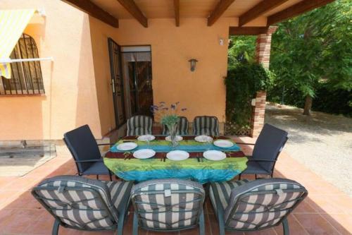 eine Terrasse mit einem Tisch und 4 Stühlen in der Unterkunft AME447 Chalet con piscina privada 9x5m y jardín vallado in Les tres Cales