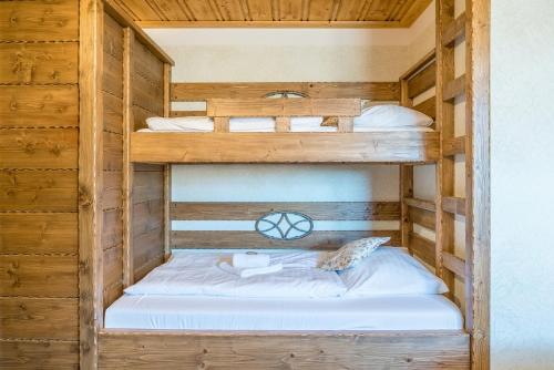 two bunk beds in a wooden cabin at Salaš Syrex in Zázrivá