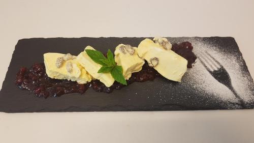 ein schwarzer Teller mit einem Dessert auf einem weißen Tisch in der Unterkunft Gasthof Neuratheis in Schnals