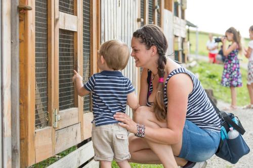 a woman and a child looking at a cage at Salaš Syrex in Zázrivá