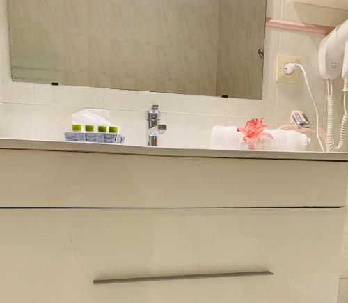 a bathroom counter with a sink and a mirror at Hotel Restaurant Llansola in Sant Carles de la Ràpita