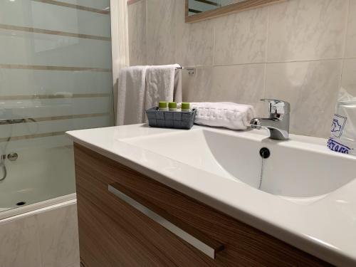 a bathroom with a white sink and a shower at Hotel Restaurant Llansola in Sant Carles de la Ràpita