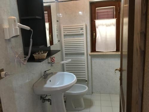 a white bathroom with a sink and a toilet at Agriturismo Lo Strettoio in Castelnuovo Berardenga