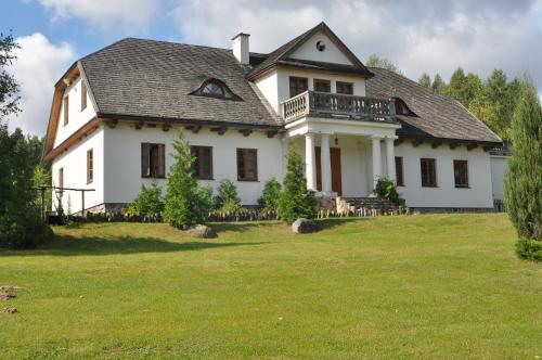 uma grande casa branca com um grande quintal em Dworek Lipowy Most em Supraśl