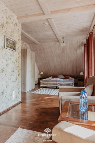 a living room with a couch and a bed at Dworek Lipowy Most in Supraśl