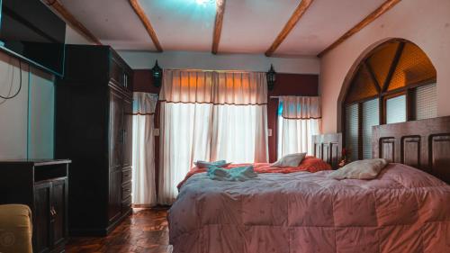 a bedroom with a large bed in front of windows at Hostal La Magia de Uyuni in Uyuni