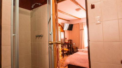 a bathroom with a shower and a bedroom with a bed at Hostal La Magia de Uyuni in Uyuni
