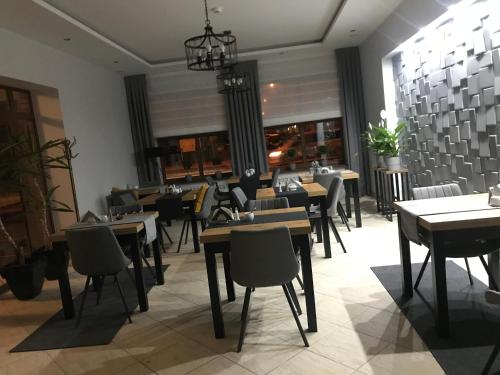 ein Restaurant mit Tischen und Stühlen in einem Zimmer in der Unterkunft Alabastro in Tomaszów Mazowiecki