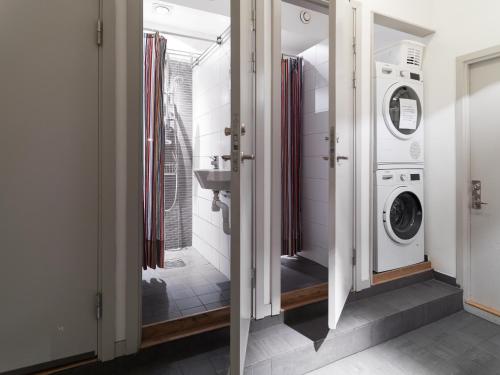 a bathroom with a washing machine and a sink at Castanea Old Town Hostel in Stockholm