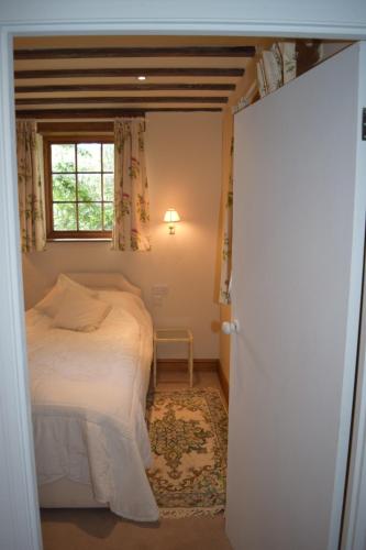a bedroom with a bed and a window at Norfolk Broads Bolthole in Stokesby