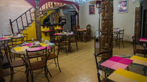 a restaurant with tables and chairs and a staircase at Hostal La Magia de Uyuni in Uyuni