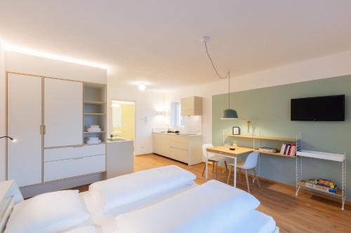 a room with a bed and a desk and a kitchen at Hus Appartement - Nr. 1 in Valdaora