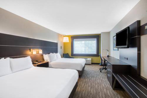 a hotel room with two beds and a flat screen tv at Holiday Inn Express Hotel & Suites Boston - Marlboro by IHG in Hudson