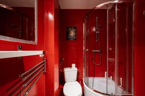 a red bathroom with a toilet and a shower at RR15 - at the Old Market Square-RYNEK up to 8 pers in Wrocław