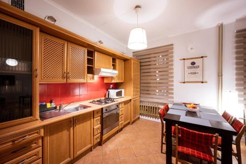 a kitchen with wooden cabinets and a sink and a table at RR15 - at the Old Market Square-RYNEK up to 8 pers in Wrocław