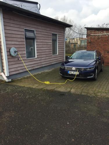a car parked next to a house with a yellow hose at Wassersportzentrum Alte Feuerwache in Brandenburg an der Havel