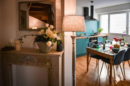 une cuisine avec une table et une lampe ainsi qu'une salle à manger dans l'établissement Duplex tout équipé, proche centre-ville COLMAR, parking, à Colmar