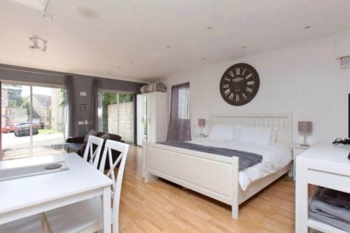 a bedroom with a bed and a clock on the wall at Self-contained Apartment in Corsham