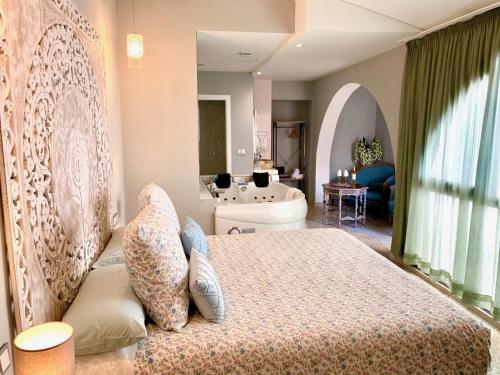 a bedroom with a large bed and a large window at Hotel Spa Adealba in Mérida