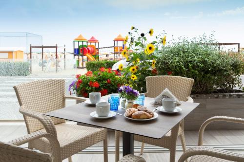 a table with a plate of food on a patio at Hotel Riviera in Bellaria-Igea Marina