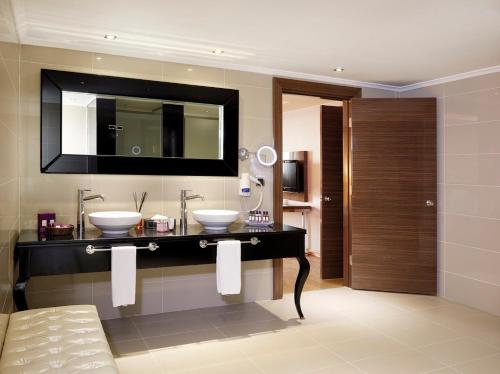 a bathroom with two sinks and a mirror at Anemon Grand Konya Otel in Konya