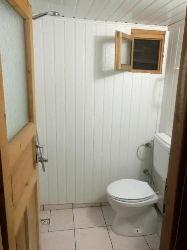 a white bathroom with a toilet and a window at Olympos Yakamoz Pansiyon in Olympos