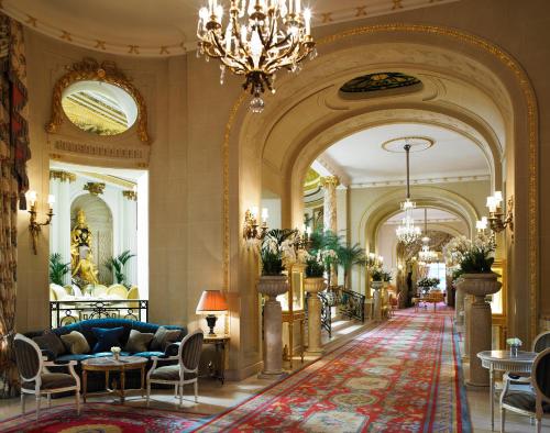 a lobby with a blue couch and a chandelier at The Ritz London in London